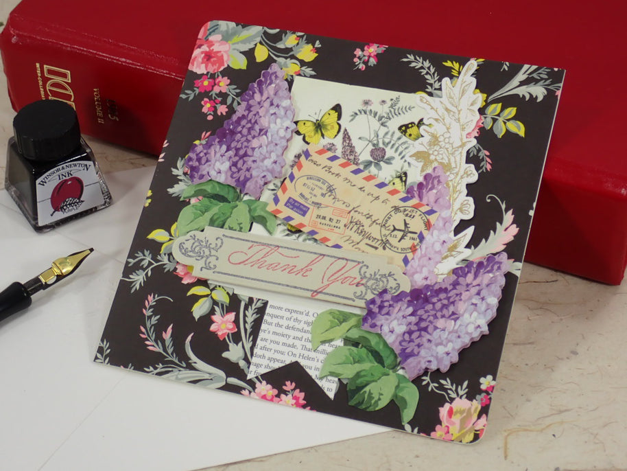 A handcrafted Thank You card with a vintage postcard design, purple hydrangea illustrations, butterflies, and a 'Thank You' ribbon banner.
