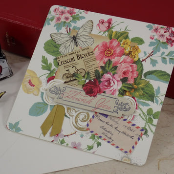 A handcrafted, Thank You card with vintage floral illustrations, a butterfly, a bicycle illustration, and layered paper embellishments.