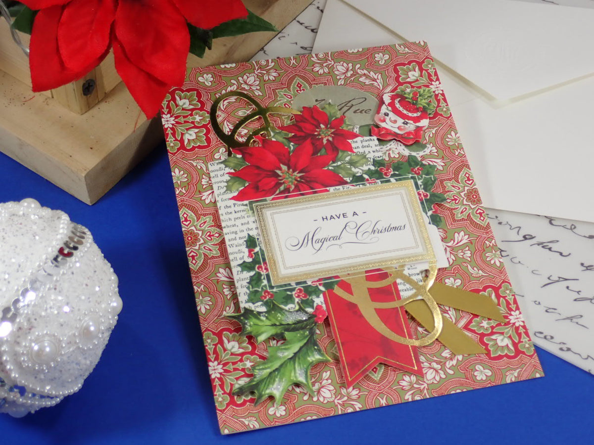 A handcrafted Christmas greeting card. Red Poinsettias and a happy snowman face. Text says 