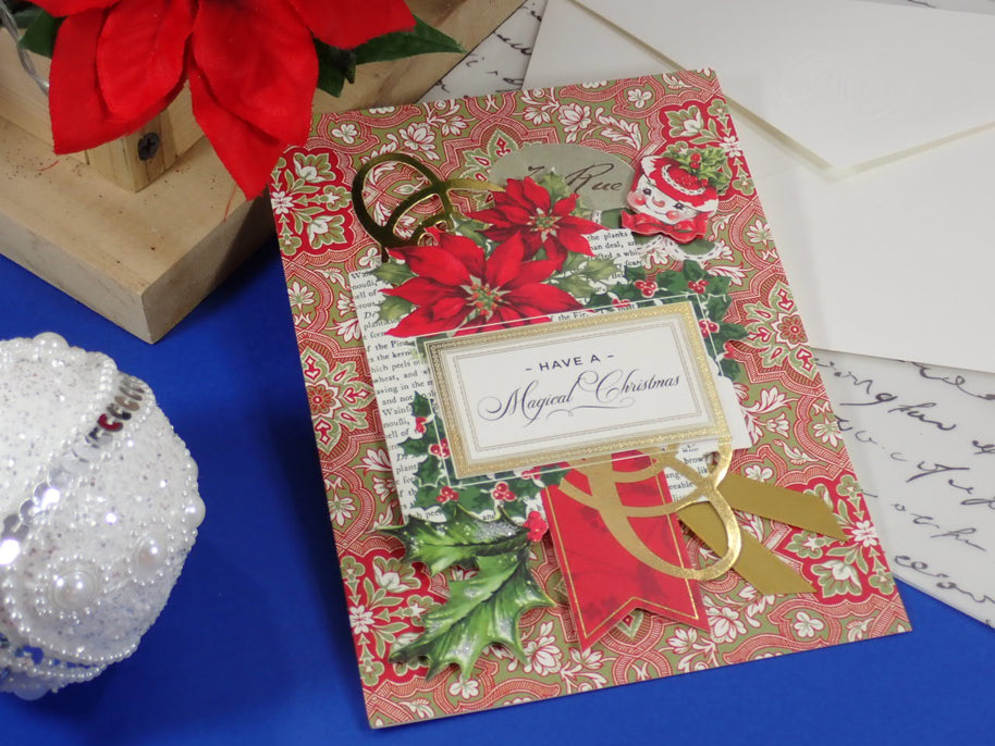 A handcrafted Christmas greeting card. Red Poinsettias and a happy snowman face. Text says "Have a Magical Christmas"