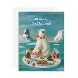 A Christmas greeting card that is artisan made. It features an illustration of a polar bear wearing a colorful beaded necklace on an iceberg surrounded by gingerbread houses, cookies, and candy canes, with the text 'Oh Goodie, It's Christmas!' above. A white envelope is partially visible behind the card.
