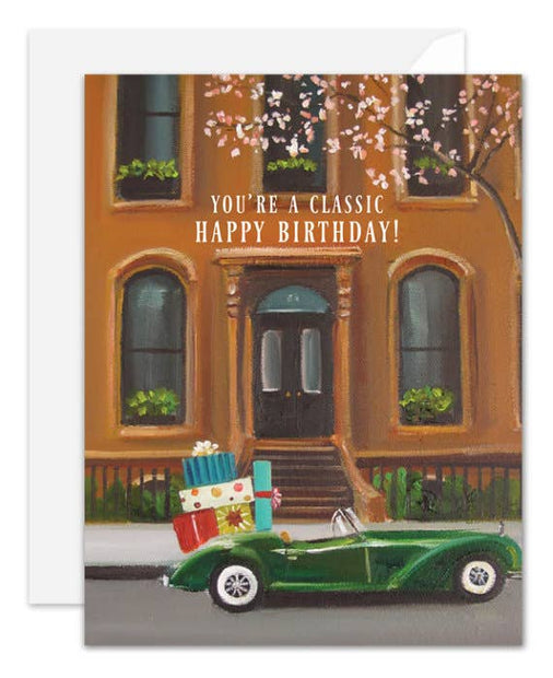 Artisan made, Birthday greeting card with a green car carrying presents in front of a brownstone building.